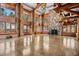 Bright living room featuring a stone fireplace, tall windows, and wooden accents at 3999 Evans Ranch Rd, Evergreen, CO 80439