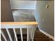 Carpeted stairs with a white banister lead to a light-filled living area with wood floors at 3613 S Olathe St, Aurora, CO 80013