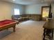 Finished basement with oversized sectional couch, pool table, bar and entertainment area at 5204 Lake Port Ave, Longmont, CO 80504