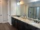 Bathroom with double sink vanity, granite countertops, and a walk-in shower at 5204 Lake Port Ave, Longmont, CO 80504