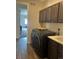 A laundry room with dark cabinets and a side by side washer dryer at 5204 Lake Port Ave, Longmont, CO 80504