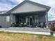 Covered patio featuring comfortable seating, an outdoor TV, and sliding glass doors at 5204 Lake Port Ave, Longmont, CO 80504