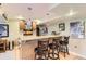 Basement bar with granite counters, bar seating, and built-in shelves with beverage refrigerator at 9229 Sugarstone Cir, Highlands Ranch, CO 80130