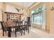 Elegant dining area with a chandelier, next to a wall of sunny windows and a full dining set at 9229 Sugarstone Cir, Highlands Ranch, CO 80130