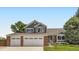 Charming two-story home with a well-manicured lawn, brick accents, and a two car garage at 9229 Sugarstone Cir, Highlands Ranch, CO 80130