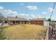 Backyard view shows sun room addition on the back of the house with detached garage and expansive yard at 3540 E 90Th Pl, Thornton, CO 80229