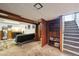 Finished basement area featuring a comfortable seating area, built in shelving, and stairs at 3540 E 90Th Pl, Thornton, CO 80229