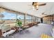 Enclosed sun room features brick walls, large windows, gray carpet, and a trio of ceiling fans at 3540 E 90Th Pl, Thornton, CO 80229