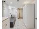 Functional basement with storage cabinets, utility sink, laundry hookups, and neutral tiled floors at 1610 Trenton St, Denver, CO 80220