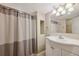 Neutral bathroom features a vanity sink, a framed mirror, and a shower with neutral curtain at 1610 Trenton St, Denver, CO 80220