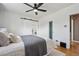 Bright bedroom with a ceiling fan, light hardwood floors and a sliding barn door at 1610 Trenton St, Denver, CO 80220