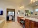 Bright bathroom with double vanity, custom cabinets, and view into the main bedroom at 4971 Bross Pl, Broomfield, CO 80023