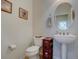 Powder room features a pedestal sink, oval mirror, and neutral decor at 4971 Bross Pl, Broomfield, CO 80023