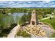 Beautiful community entrance with stone monument, lush landscaping, and scenic pond view at 4971 Bross Pl, Broomfield, CO 80023