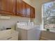 Laundry room with overhead cabinets, a large window, and a laundry sink at 4971 Bross Pl, Broomfield, CO 80023