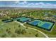 Aerial view of tennis courts in a picturesque setting with lush landscaping and mountain views at 4971 Bross Pl, Broomfield, CO 80023