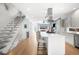 Open-concept kitchen with stainless appliances, waterfall island, and view into the living room at 2242 W 34Th Ave, Denver, CO 80211