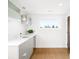Bright laundry room features quartz counters, grey cabinets, stainless sink, and view to the outdoors at 2242 W 34Th Ave, Denver, CO 80211