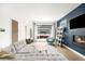 Bright living room with gray sectional, fireplace, accent wall, and view into the backyard at 2242 W 34Th Ave, Denver, CO 80211