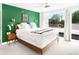 This sunny main bedroom features a bright green accent wall, wooden dresser and bedside tables at 2242 W 34Th Ave, Denver, CO 80211
