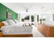 Bright main bedroom boasts a bold green accent wall, ceiling fan and large sunny windows at 2242 W 34Th Ave, Denver, CO 80211