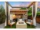 Outdoor patio area at sunset with seating around the fire pit, landscaping, and covered pergola at 2242 W 34Th Ave, Denver, CO 80211