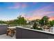 Rooftop deck featuring skyline views at sunset, with wooden table and chairs at 2242 W 34Th Ave, Denver, CO 80211