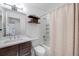 Bathroom with a tub and shower with a curtain, a toilet, and a wood vanity with a white countertop at 6435 S Dayton St # 103, Englewood, CO 80111