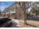 Brick condo building with balconies, exterior stairs, sidewalk, mature trees, and a parked car at 6435 S Dayton St # 103, Englewood, CO 80111