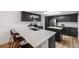 Contemporary kitchen with a large island, stylish bar stools, stainless steel appliances, and modern fixtures at 6435 S Dayton St # 103, Englewood, CO 80111