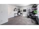 A home office featuring carpet flooring, two shelves with plants, and a black board at 6435 S Dayton St # 103, Englewood, CO 80111