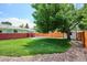 The large backyard boasts lush green grass, a storage shed, and an abundance of mature shade trees at 1687 S Field Ct, Lakewood, CO 80232