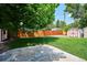 Well-maintained backyard featuring green grass, a storage shed, a concrete patio, and a wooden fence for privacy at 1687 S Field Ct, Lakewood, CO 80232