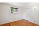 Bright bedroom featuring hardwood floors, a large window offering neighborhood views, and a spacious closet at 1687 S Field Ct, Lakewood, CO 80232
