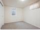 The empty bedroom has white wooden paneled walls, a gray carpet, and a small window at 1687 S Field Ct, Lakewood, CO 80232