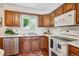 Kitchen features wood cabinets, white appliances, and ample counter space at 1687 S Field Ct, Lakewood, CO 80232