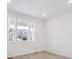 Bright bedroom featuring large windows and wood-look flooring for a modern aesthetic at 45928 Gentry Ave, Bennett, CO 80102
