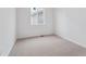 Neutral carpet and a window providing natural light in a bedroom at 45928 Gentry Ave, Bennett, CO 80102