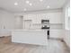 Modern kitchen featuring a center island, white cabinetry, and stainless steel appliances at 45928 Gentry Ave, Bennett, CO 80102