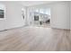 Bright living room featuring wood-look flooring and sliding glass doors leading to the backyard at 45928 Gentry Ave, Bennett, CO 80102