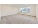 A primary bedroom includes a bright and open space with three large windows and plush carpeting at 4586 Windmill Dr, Brighton, CO 80601