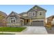 Charming two-story home featuring a well-manicured lawn, attached two-car garage, and stone accents at 4586 Windmill Dr, Brighton, CO 80601