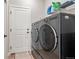Modern laundry room with front loading washer and dryer and plenty of storage space on the wire rack shelving at 17801 E 95Th Pl, Commerce City, CO 80022