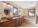 Elegant bathroom with double sinks, granite countertops, and a soaking tub at 3028 Olympia Cir, Evergreen, CO 80439