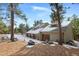 Home's exterior showcases a three car garage and landscaping at 3028 Olympia Cir, Evergreen, CO 80439