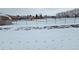 Snowy backyard with fenced playground adjacent to the property at 26 S Gay Dr, Longmont, CO 80501