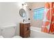Bathroom featuring a shower and tub combination, modern vanity, and unique glass block window at 1440 S Dahlia St, Denver, CO 80222