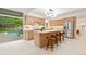Modern kitchen featuring wood cabinets, stainless steel appliances, island with seating, and view of the pool at 1440 S Dahlia St, Denver, CO 80222