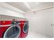 Bright laundry room featuring a modern red washer and dryer set, and white ceilings at 1440 S Dahlia St, Denver, CO 80222