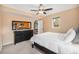 Bright bedroom with a plush bed, dark dresser, ceiling fan, and a view of the ensuite bathroom at 14887 W 49Th Pl, Golden, CO 80403